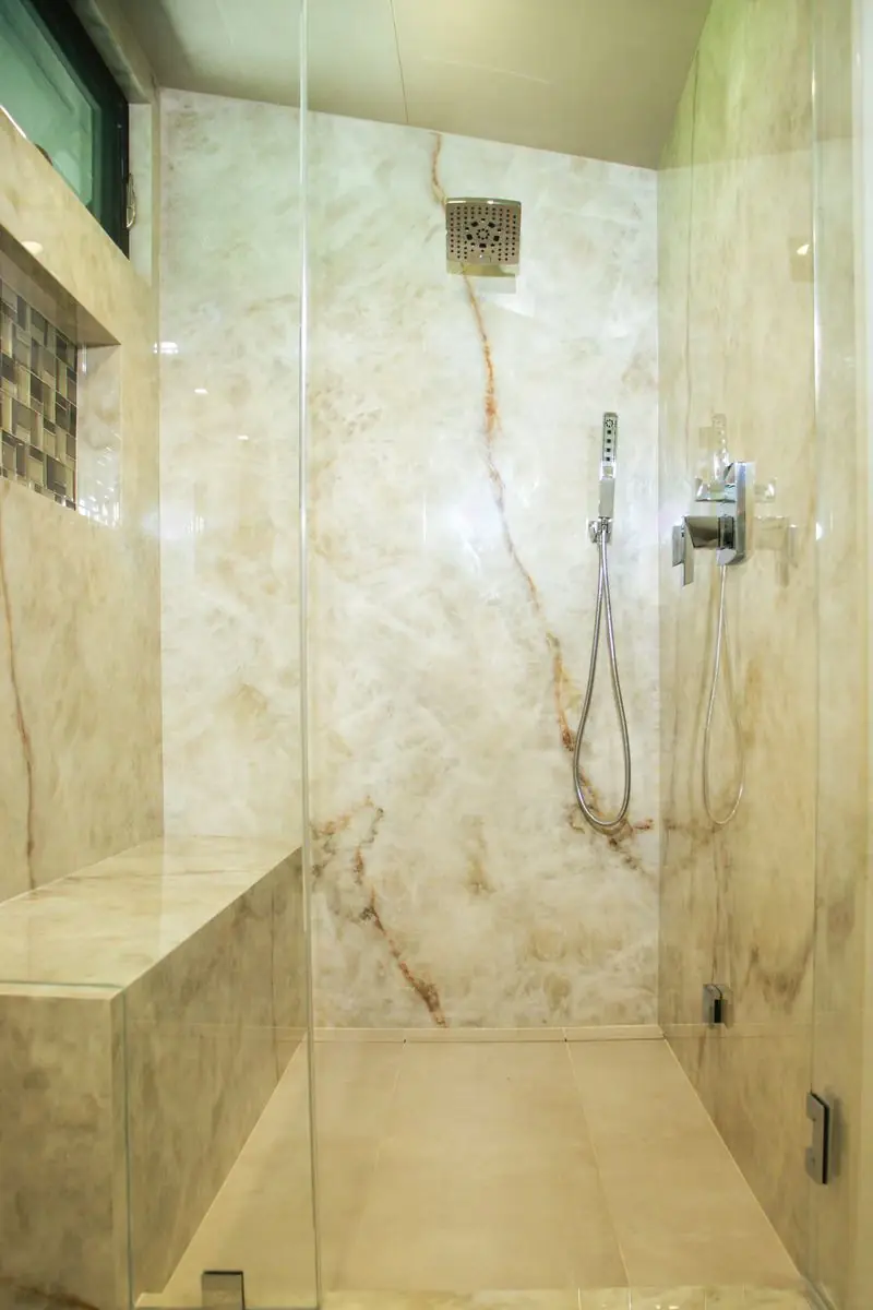 Walk-in shower clad in book-matched quartzite with bench seat