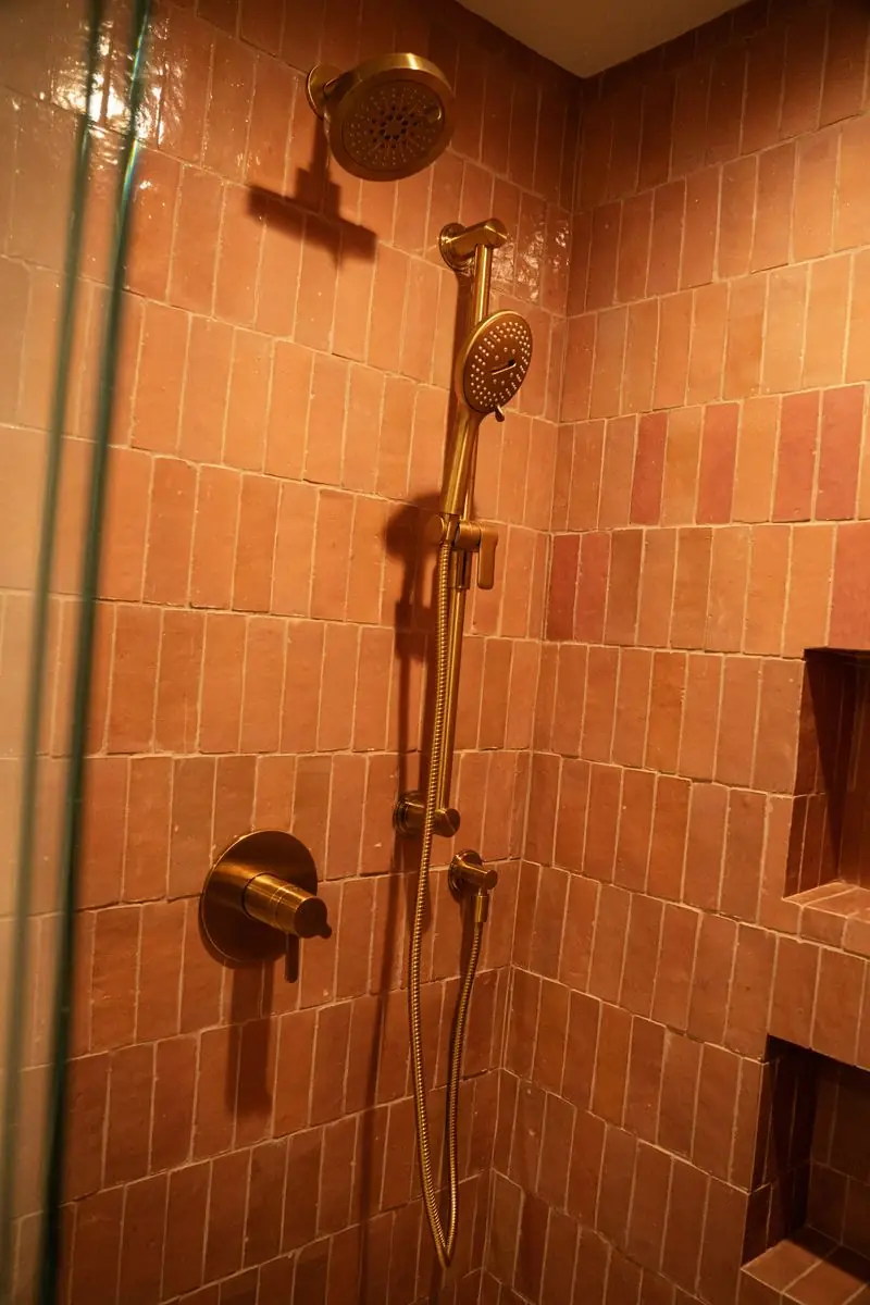 Bathroom with terracotta zellige tile and brass fixtures