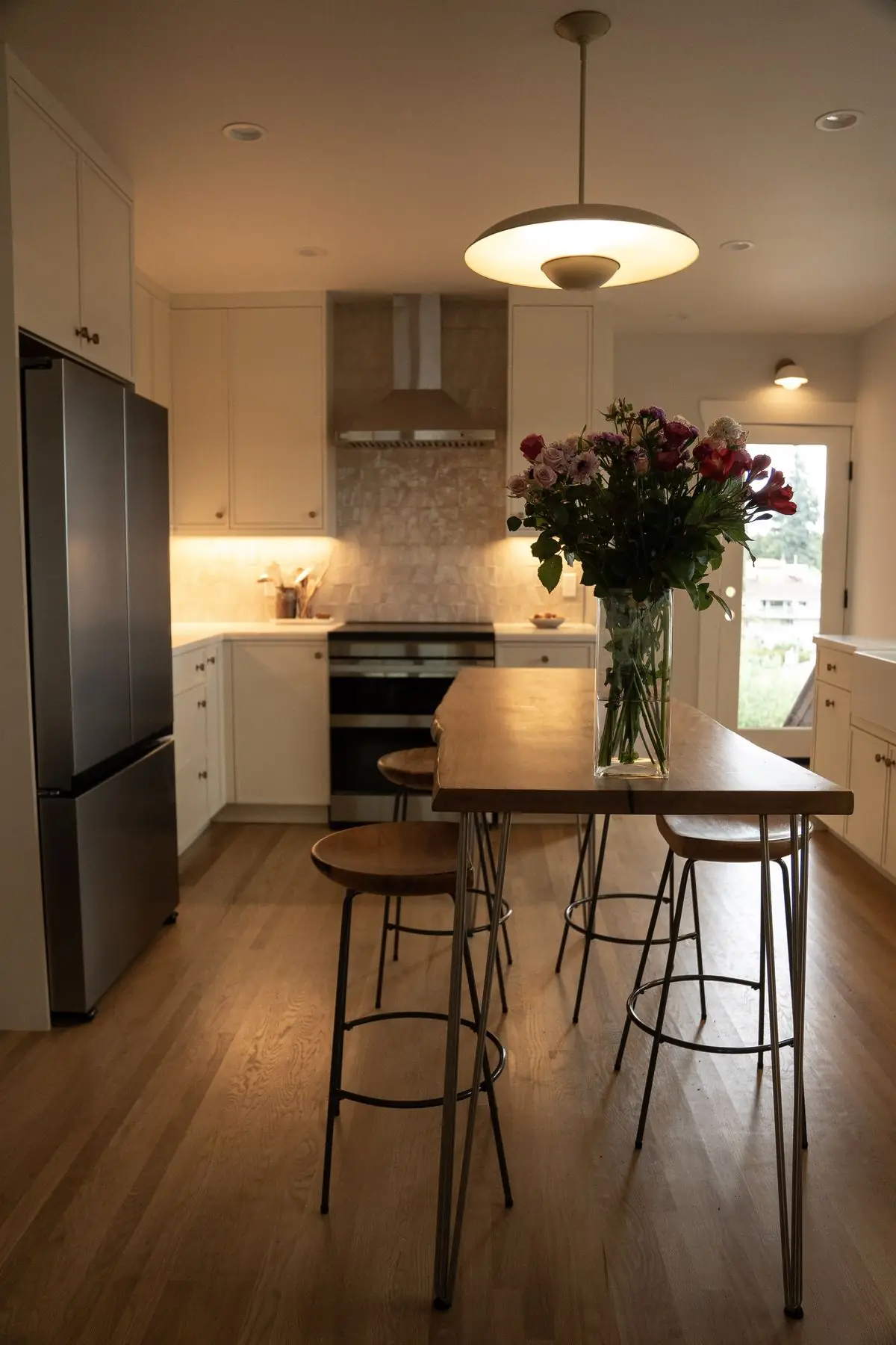 Remodeled white kitchen with island, brass fixtures and wood floors in Oakland