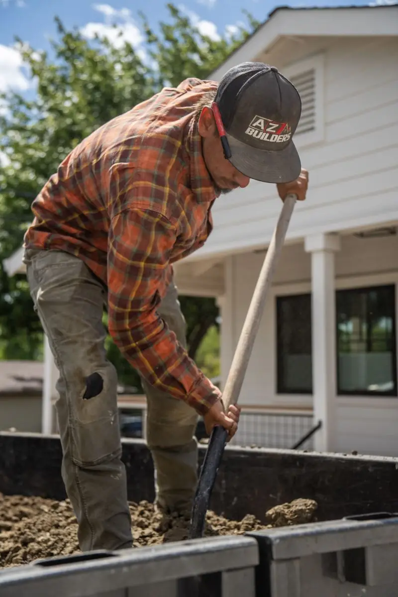 AZ Elevated Builders crew member grading a site by hand